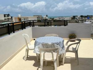 コトヌーにあるAHOUEDJI Guest House - Palais Urbain avec Balcon & Vue Merのバルコニー(テーブル、椅子付)