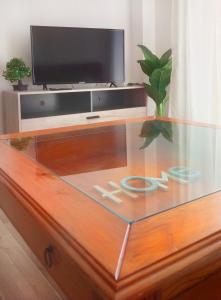 a living room with a tv and a glass table at Europa Moderna Apartamento in Gandía
