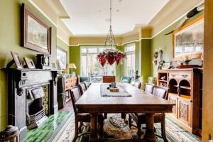 a dining room with green walls and a table and chairs at Victorian Guest House 200m from the Seafront in West Kirby