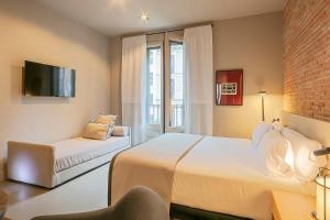 A bed or beds in a room at Uma Suites Pau Claris