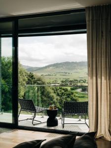 Moody Luxury Home in the Wine Region في ريتشموند: غرفة معيشة مع نافذة كبيرة مع كرسيين