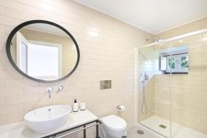 a white bathroom with a sink and a shower at Quinta Rolim do Bouro By Sé Apartamentos in Roucio +34 photos