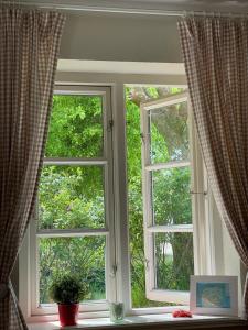 2 ventanas en una sala de estar con cortinas en Friisk Aran, en Alkersum