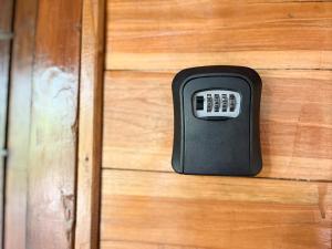 a black remote control on a wooden drawer at Little Bear Bungalows in Gili Air