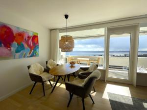 - une salle à manger avec une table et des chaises et une vue sur l'océan dans l'établissement Panoramic Auszeit mit Meerblick, à Sierksdorf