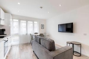 a living room with a couch and a tv at Finsbury Park Retreat Modern Comfort in London