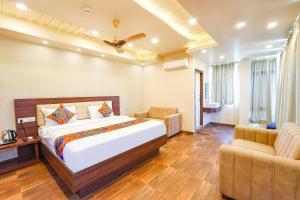 pokój hotelowy z łóżkiem i 2 krzesłami w obiekcie FabHotel Grand Falcon w mieście Bengaluru