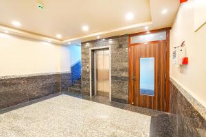 korytarz z drewnianymi drzwiami i schodami w obiekcie FabHotel Grand Falcon w mieście Bengaluru