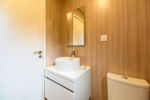 uma casa de banho com um lavatório branco e um espelho. em Massassi Plaza em Cornimont