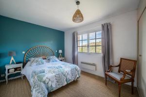 a blue bedroom with a bed and a chair at Maison Le Boulou - Grand jardin piscine privée in Le Boulou