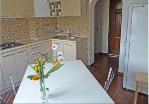 a kitchen with a table with a vase of flowers on it at Willa Pod Modrzewiem in Szczyrk