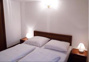 シュチルクにあるWilla Pod Modrzewiemのベッドルーム1室(白いシーツとランプ2つ付)