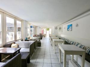 a restaurant with couches and tables and windows at Anny Studios & Rooms Perissa Beach in Perissa
