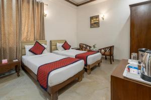 Spree Hotel Agra - Walking Distance to Tajmahal في آغْرا: غرفه فندقيه سريرين وتلفزيون