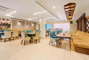 a restaurant with a couch and tables and chairs at Hotel Green - Behind Parmarth Niketan in Rishīkesh