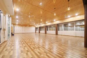 ein leerer Fitnessraum mit Holzboden und großer Halle in der Unterkunft Green Hotel - Behind Parmarth Niketan in Rishikesh