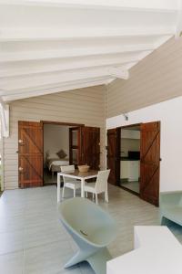 een kamer met een tafel en stoelen en een slaapkamer bij Habitation TABANON in Petit-Bourg