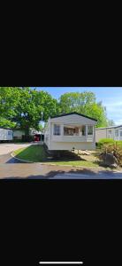 a small white house with a lot of windows at Paradise Holiday home in Lytchett Minster