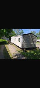 a large white trailer with a gambrel roof at Paradise Holiday home in Lytchett Minster