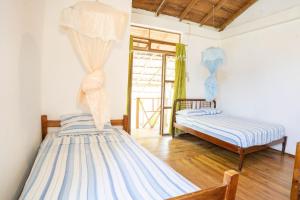 a bedroom with two beds and a window at Bed and Breakfast Puerto López in Puerto López