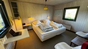 Veludstyret sommerhus i unik natur 350 m fra lækker badestrand - helårsbolig في Saltum: غرفة نوم بسرير في غرفة صغيرة