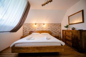 Un dormitorio con una cama grande y una ventana. en La Bunici, en Vişeu de Sus
