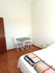 Cette chambre comprend une table, des chaises et un lit. dans l'établissement Suíte privativa Gigá, à Brotas