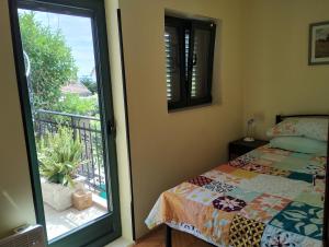 ein Schlafzimmer mit einem Bett und einem Balkon in der Unterkunft Monteview Duplex in Herceg-Novi
