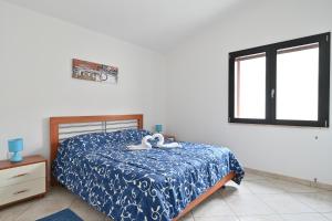 ein Schlafzimmer mit einem Bett mit zwei Schwänen darauf in der Unterkunft Casa Bari Sardo per più famiglie in Bari Sardo