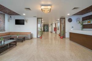 Spree Hotel Agra - Walking Distance to Tajmahal في آغْرا: لوبى به أريكة وتلفزيون على الحائط