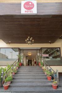 a hotel with stairs and potted plants in front of it at Spree Hotel Agra - Walking Distance to Tajmahal in Agra