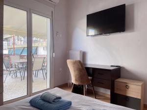 um quarto com uma cama, uma secretária e uma varanda em 2-bedroom Winter Apartment em Atenas