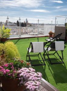 - un balcon avec 2 chaises, une table et des fleurs dans l'établissement Hotel Plaza Santa Lucía, à Séville