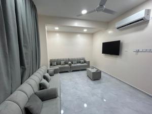 uma sala de espera com sofás e uma televisão de ecrã plano em Najm Chalet em Ḩayl Yaman