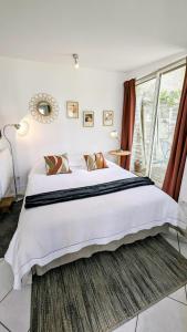 Un dormitorio con una cama grande y una ventana en A la ville comme à la campagne, en Sainte-Savine