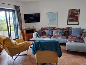 sala de estar con sofá, mesa y sillas en Monteview Duplex, en Herceg-Novi