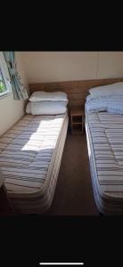 two beds sitting next to each other in a room at Paradise Holiday home in Lytchett Minster