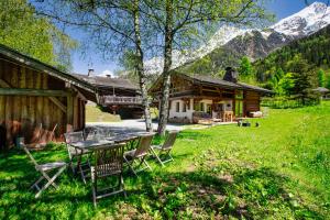 a table and chairs in front of a cabin at Warm & Cosy 3BR Chalet w/ Fireplace in Nature in Les Houches
