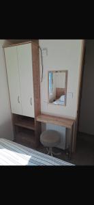 a dresser with a mirror and a stool in a room at Paradise Holiday home in Lytchett Minster