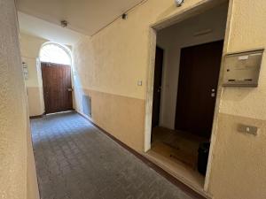 moderna ed elegante Residenza nel centro di Pavia في بافيا: غرفه فاضيه فيها باب وممر