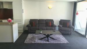 a living room with two couches and a coffee table at Central Apartment in Hanmer Springs