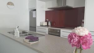 a kitchen with a sink and a vase with a flower at Central Apartment in Hanmer Springs