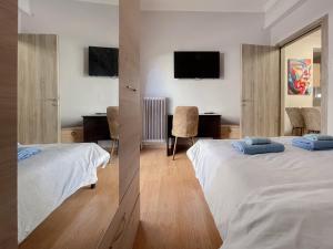 um quarto de hotel com duas camas e uma secretária em 2-bedroom Winter Apartment em Atenas