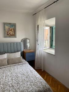 Un dormitorio con una cama y un espejo y una ventana. en San Marco Makarska, en Makarska