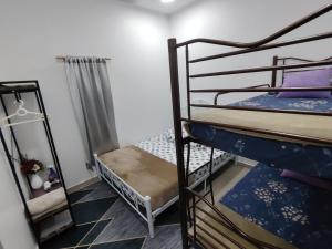 a dorm room with two bunk beds and a ladder at Sri MaLati Homestay and Event Space in Balik Pulau