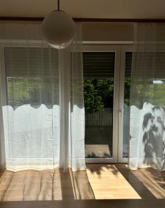 a window with white curtains in a room at Westfalenpark Apartment with terrace and free parking in Dortmund