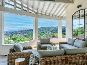 an outdoor living room with wicker furniture and large windows at Villa moderne 6 CH pour 12 avec piscine privée, clim et parking aux Issambres - FR-1-768-24 in Les Issambres