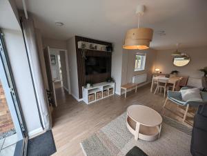 un soggiorno con un divano e un tavolo di Hoot Hollow - Hot Tub Hideaway a Heacham