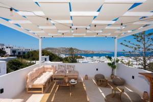 a patio with a couch and tables on a roof at Boutique di Vito in Mýkonos City