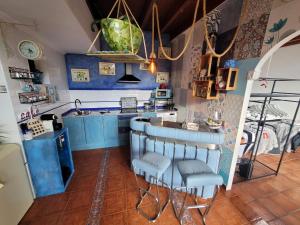 uma cozinha com armários azuis e bancos de bar em Precioso bajo con piscina en Soto de la marina em Soto de la Marina